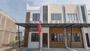 A modern two-story residential building with a covered entrance, multiple windows, and air conditioning units. - OYO Life 3248 Vision Residence Karawang (Karawang)