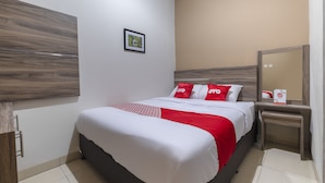 A hotel room with a bed, a bedside table, a mirror, and a picture on the wall. - OYO Life 3248 Vision Residence Karawang (Karawang)