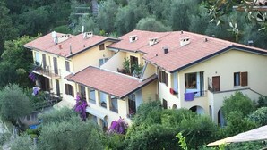 A row of terraced houses with red-tiled roofs, surrounded by lush greenery.