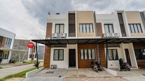 A modern two-story building with a covered entrance and multiple air conditioning units. - OYO Life 90211 I-sidji Inn (Karawang)