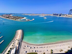 Eine Luftaufnahme eines Küstenresorts mit Sandstrand, klarem blauen Wasser und einer Marina mit Booten.