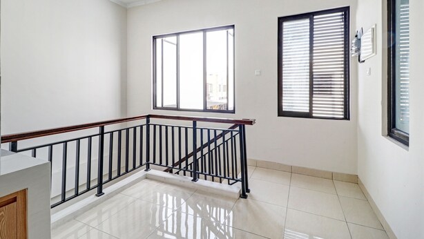 A clean, modern interior with a polished floor, a wooden railing, and large windows with blinds. - Hotel O Marta Residence (Karawang)