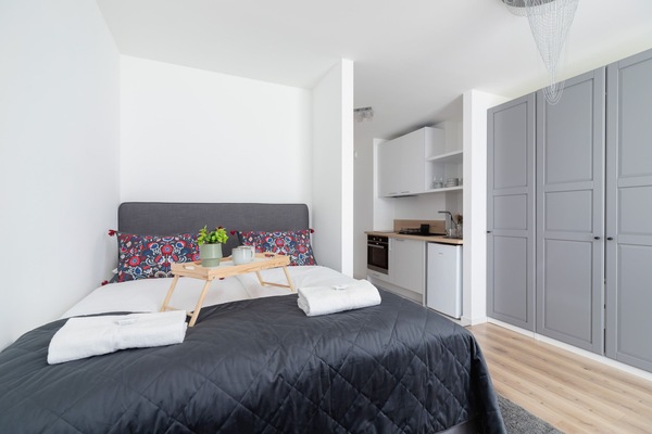 The living area features a sleek dining table and a flat-screen television.