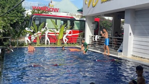 Ein Poolbereich, im Hintergrund ein Hotel namens "Window Homestay".