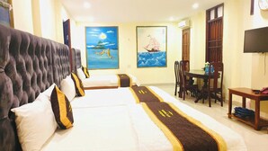 Ein Hotelzimmer mit zwei Betten, einem Essbereich und Bildern an den Wänden.