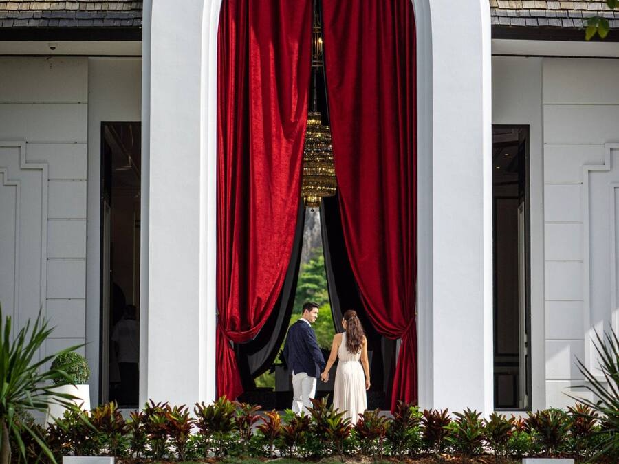 A sign for "The Soul Luxury Wellness and Mindfulness Resort" with a white building and red curtains.
