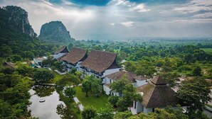 Un conjunt d'edificis de planta tradicional, envoltat de vegetació abundant i una massa d'aigua.