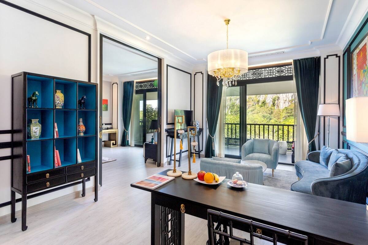 A modern living room with a dark wooden coffee table, a blue sofa, and a blue shelving unit with decorative items.