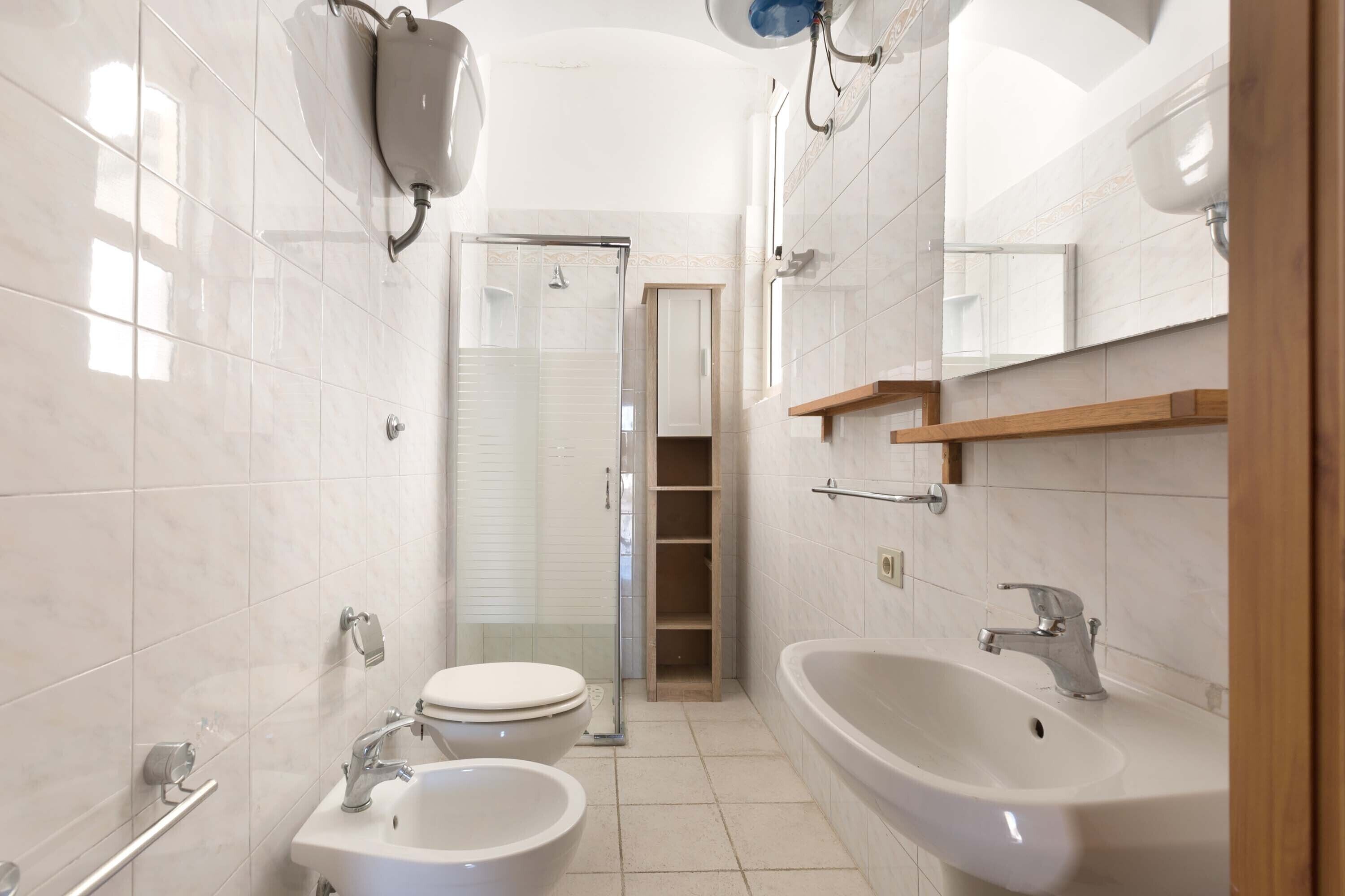 A modern bathroom with a toilet, bidet, and sink.