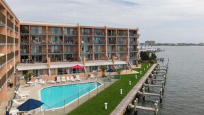 Um hotel com piscina, área de estar ao ar livre e vista para a água.