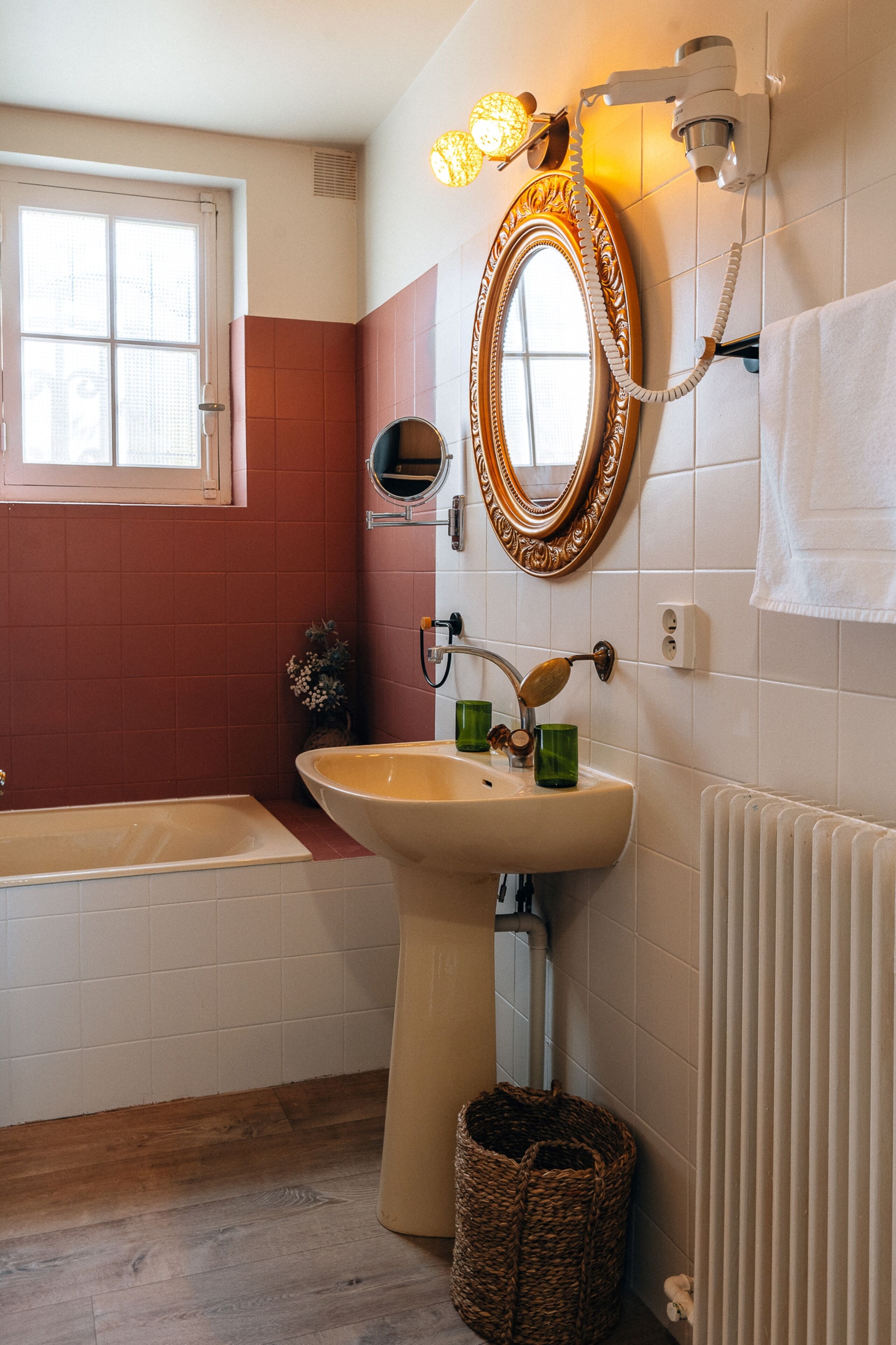 A bathroom with a bathtub, sink, and mirror.