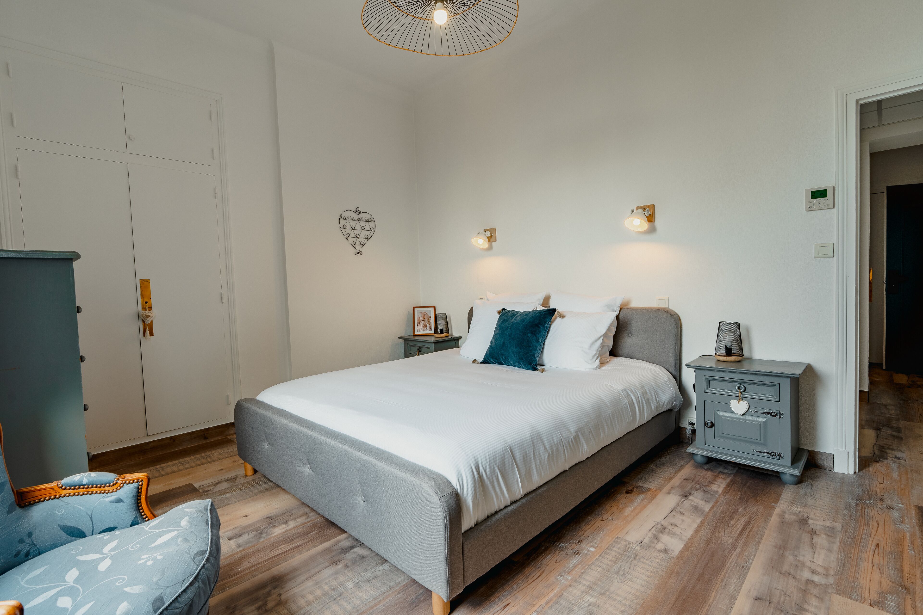 A bedroom with a bed, bedside tables, a wardrobe, and a heater.