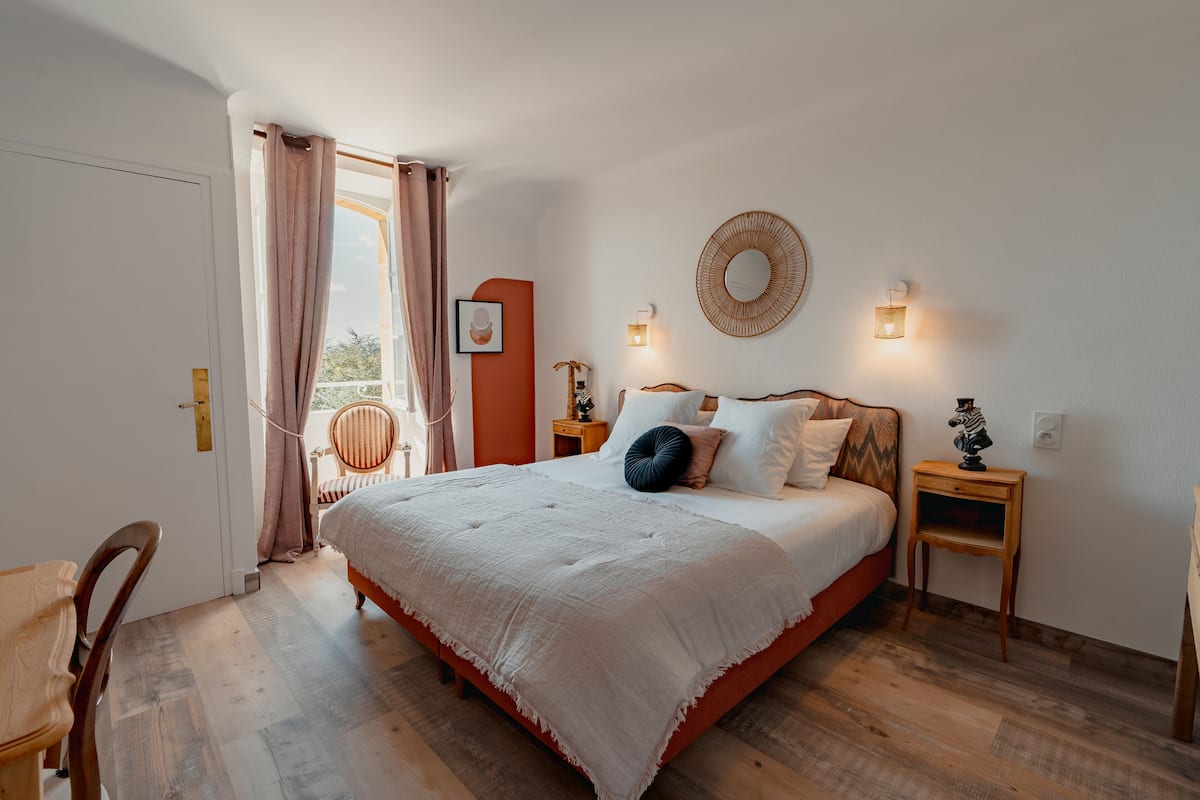 A bedroom with a bed, bedside tables, a chair, and a door.