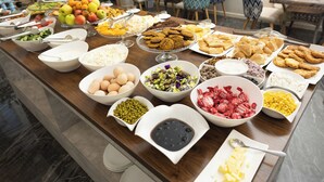 Buffet com diversas opções de comida, incluindo frutas, legumes e sobremesas.