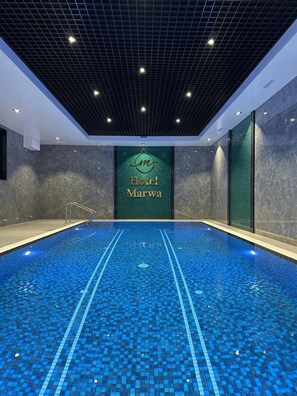 An indoor swimming pool with a tiled floor and a sign reading "Hotel Marwa". - Marwa Hotel (Tashkent)