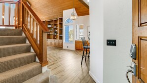 Un interior espacioso con una escalera de madera, una zona de cocina y un comedor.