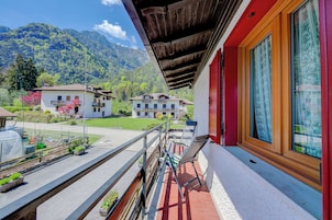 Un balcone con vista su una montagna e un villaggio.