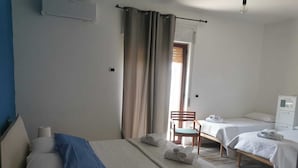 A hotel room with two beds, a chair, a desk, and a window with curtains. - b&b Crispino (Belvedere Marittimo)