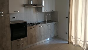 A modern kitchen with a gas stove, oven, stainless steel cabinets, and a range hood. - b&b Crispino (Belvedere Marittimo)
