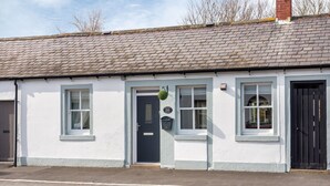 A traditional white building with a dark door, multiple windows, and a black gate. - Stunning 1-bed Cottage Near Carlisle With Hot tub (Carlisle)