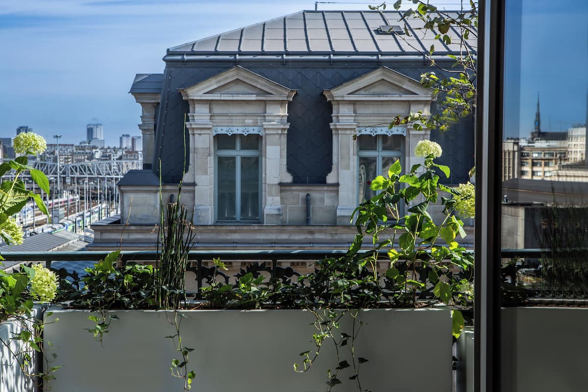 A building with classical architecture, large windows, and a view of the cityscape.