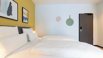 Quarto de hotel com uma cama, mesa de cabeceira, relógio de parede e uma porta.