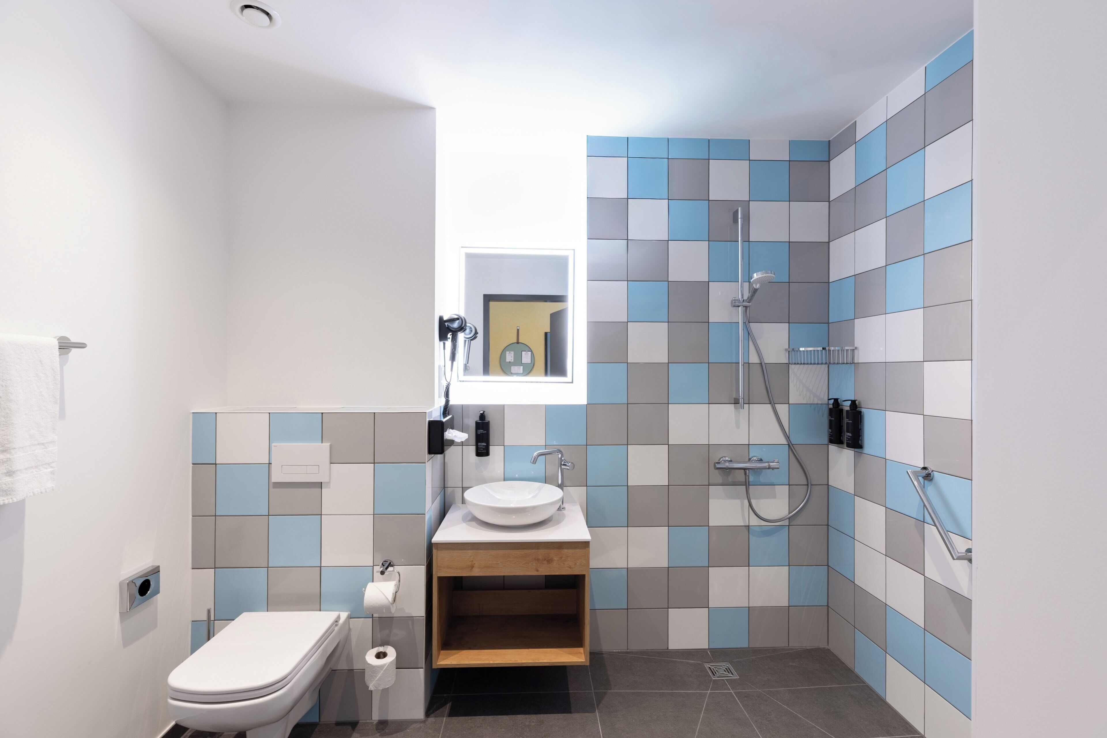 A modern bathroom with a toilet, sink, and shower.
