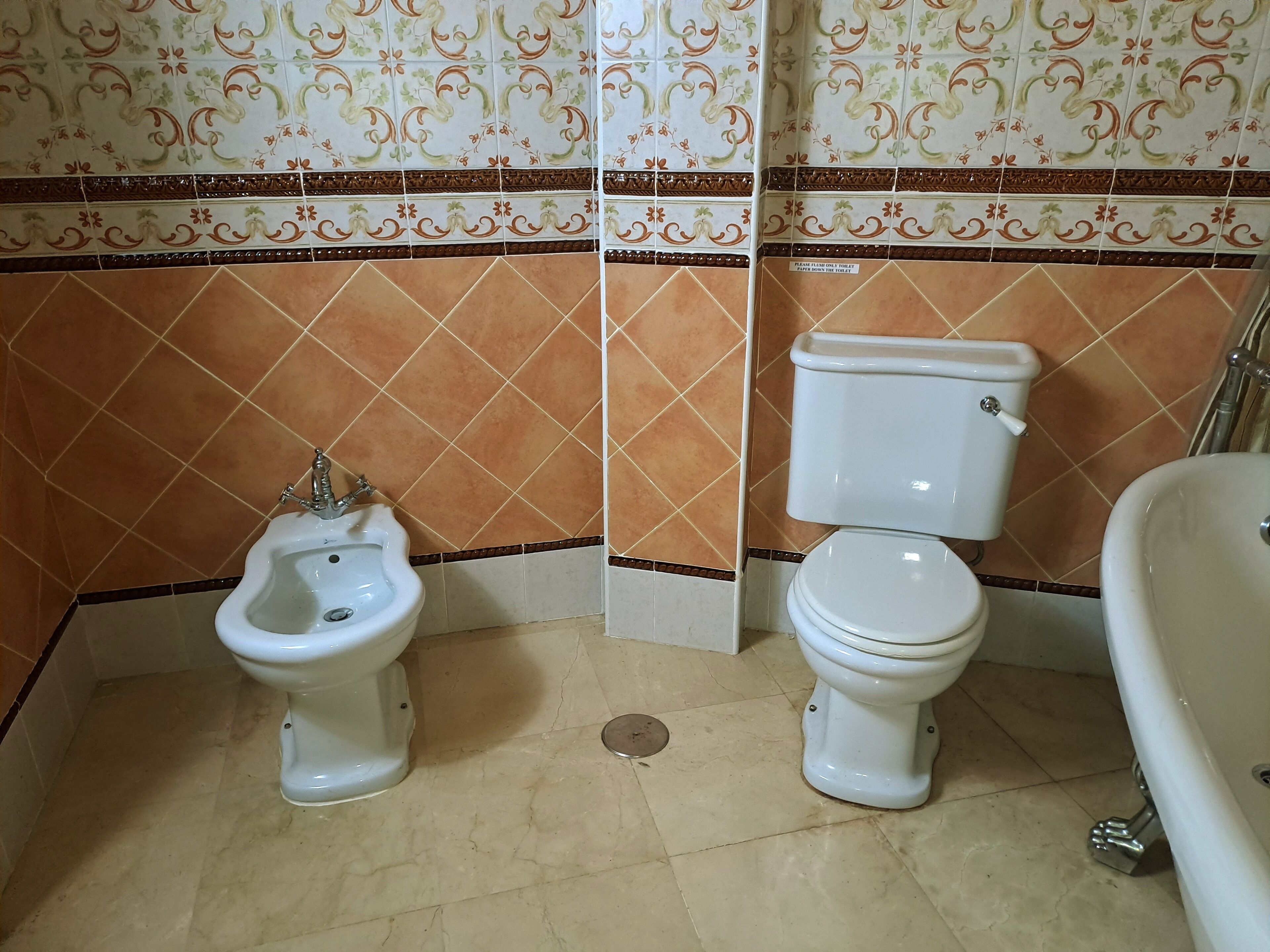 Ein Badezimmer mit Bidet, Toilette und Badewanne.