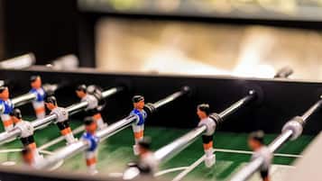 A close-up of a foosball table with players in blue and orange uniforms.