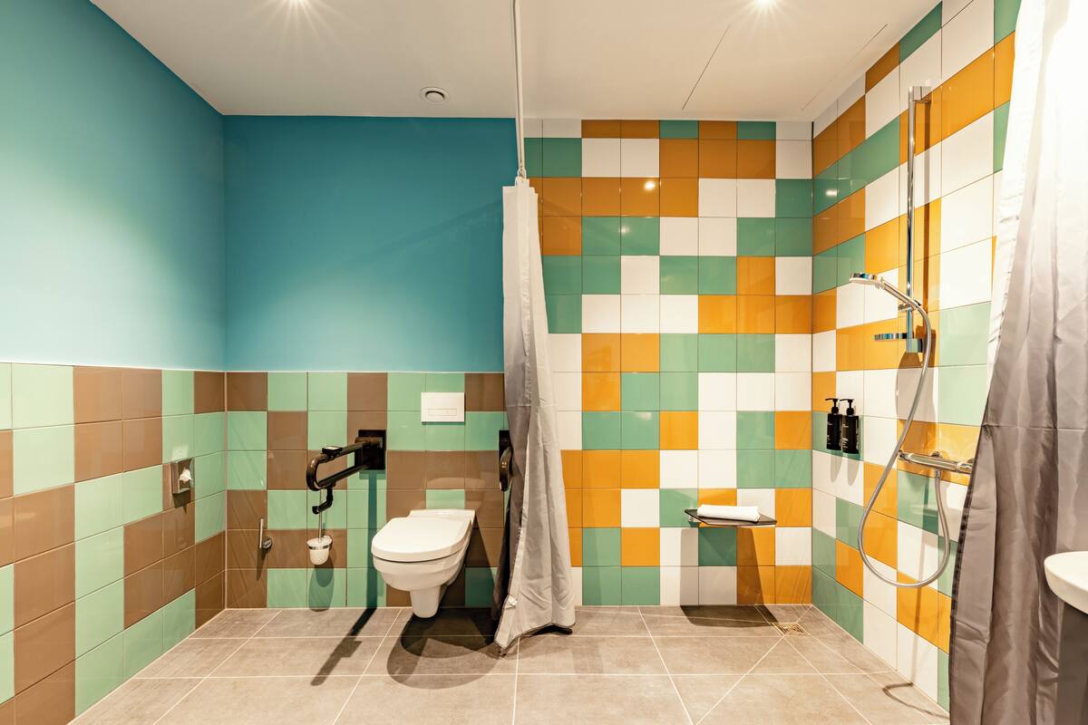 A bathroom with a toilet, shower, and sink.