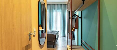 A hotel room with a bed, a mirror, a wardrobe, and a staircase.
