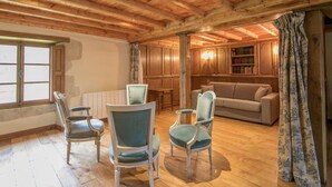 A cozy room with wooden beams, a sofa, and a bookshelf. - The Manoir de Damigny in Normandy near the landing beaches and Bayeux (SAINT MARTIN DES ENTREES)