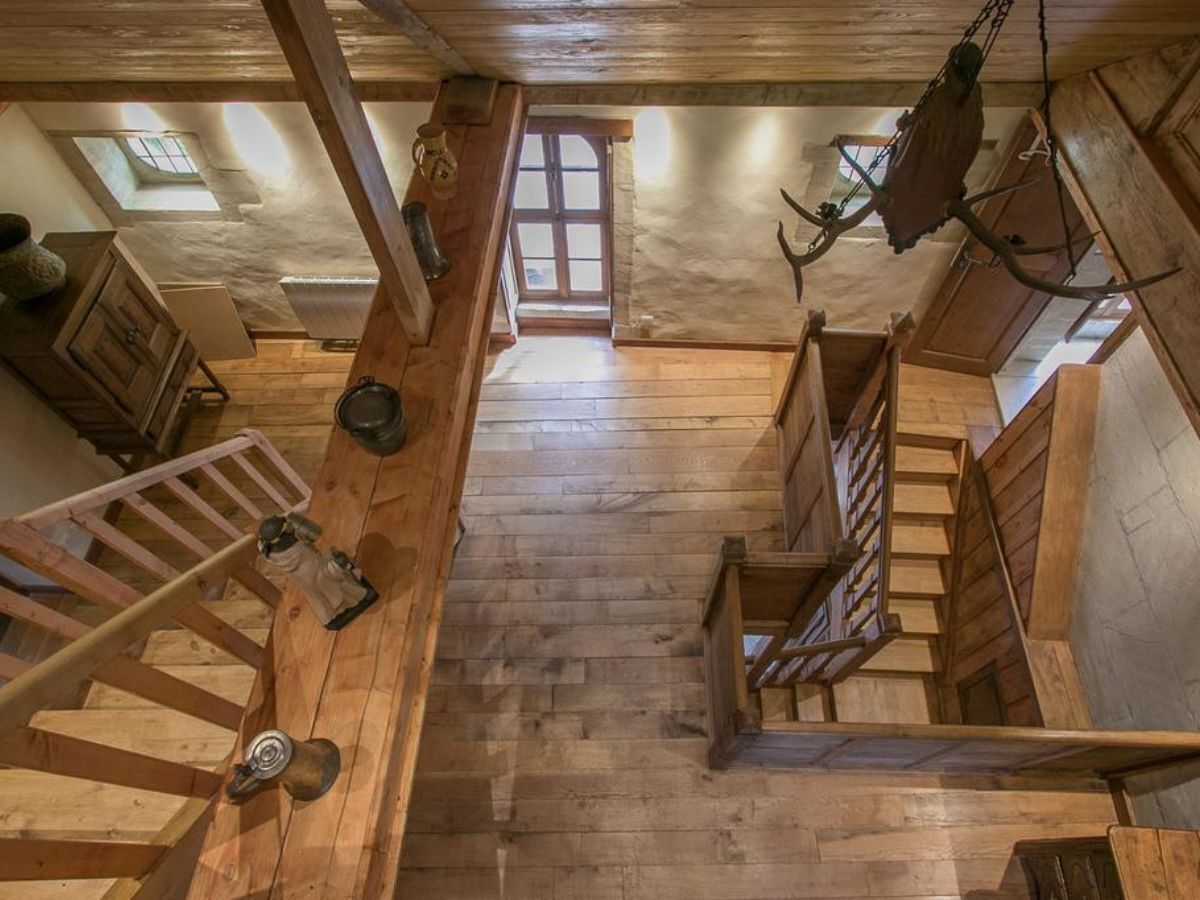 Una scala in legno che dà su una finestra e una porta in cima.