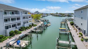 A marina with docked boats, a waterway, and buildings with balconies.