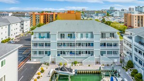 A multi-story hotel with balconies, a dock, and a view of the water.