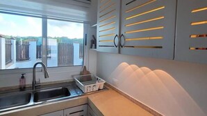 A modern kitchen with a window, sink, and cabinets.