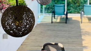 Una terraza de madera con mesa y sillas, con vista a un paisaje marino.