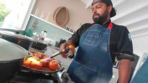 Una persona cocinando en una cocina con salpicadero de azulejos y electrodomésticos modernos.