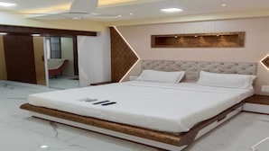 Quarto moderno com uma cama grande, ventilador de teto e piso de mármore.