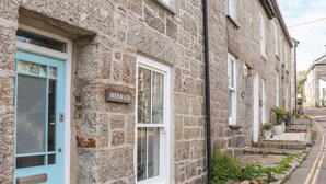 A stone building with a turquoise door and a sign reading "MERMAID". - Mermaid Cottage (Penzance)