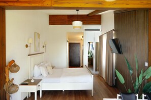 A bedroom with a bed, bedside table, lamp, and a TV. - Yörükali Tesisleri (Adalar)