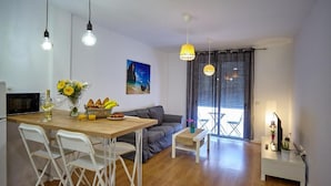 A modern living space with a dining area, a sofa, and a TV. - Apartamento Sol y Mar (Arona)