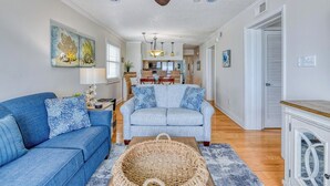 A living room with a ceiling fan, two sofas, a dining area, and a kitchen in the background. - Sea Master 315 - Three Bedroom, Three Bathroom, Oceanfront Condo (Garden City Beach)