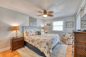 Cozy retreat with a large bed, nightstand, and wicker side table.