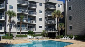 Enjoy a refreshing dip in the pool surrounded by lush palm trees and comfortable lounge chairs.