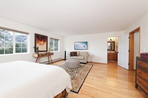 A spacious bedroom with a large bed, a wooden dresser, a sofa, and a view of a mountain through the windows. - Luxury Home - Huge Deck - Great Views - Hot Tub/Fire Table - 2 Miles to Purg (Durango)