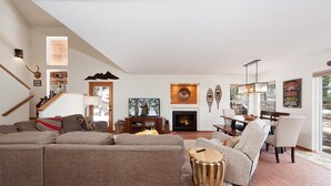 A spacious living room with a fireplace, a dining area, and a staircase leading to another level. - Luxury Home - Huge Deck - Great Views - Hot Tub/Fire Table - 2 Miles to Purg (Durango)