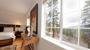 A bedroom with a large window, a bed, a nightstand, and a dresser. - Luxury Home - Huge Deck - Great Views - Hot Tub/Fire Table - 2 Miles to Purg (Durango)