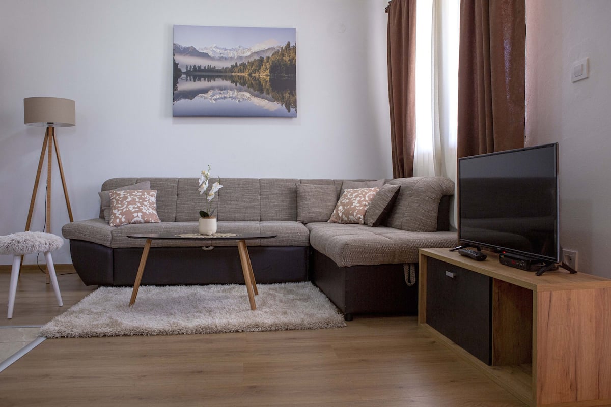 Appartamento Deluxe | Area soggiorno | TV a schermo piatto 42 pollici con canali via cavo, TV