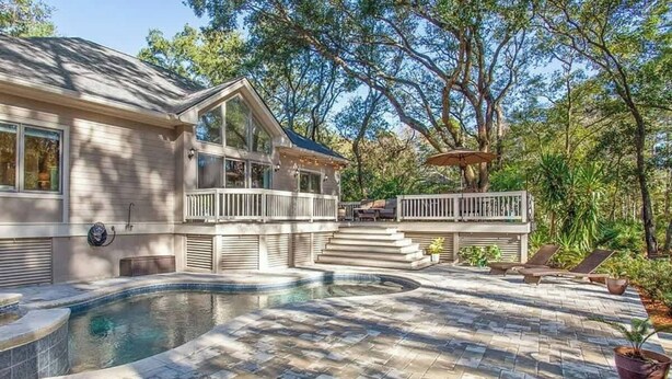 Une maison avec une piscine, une terrasse couverte et un espace patio.